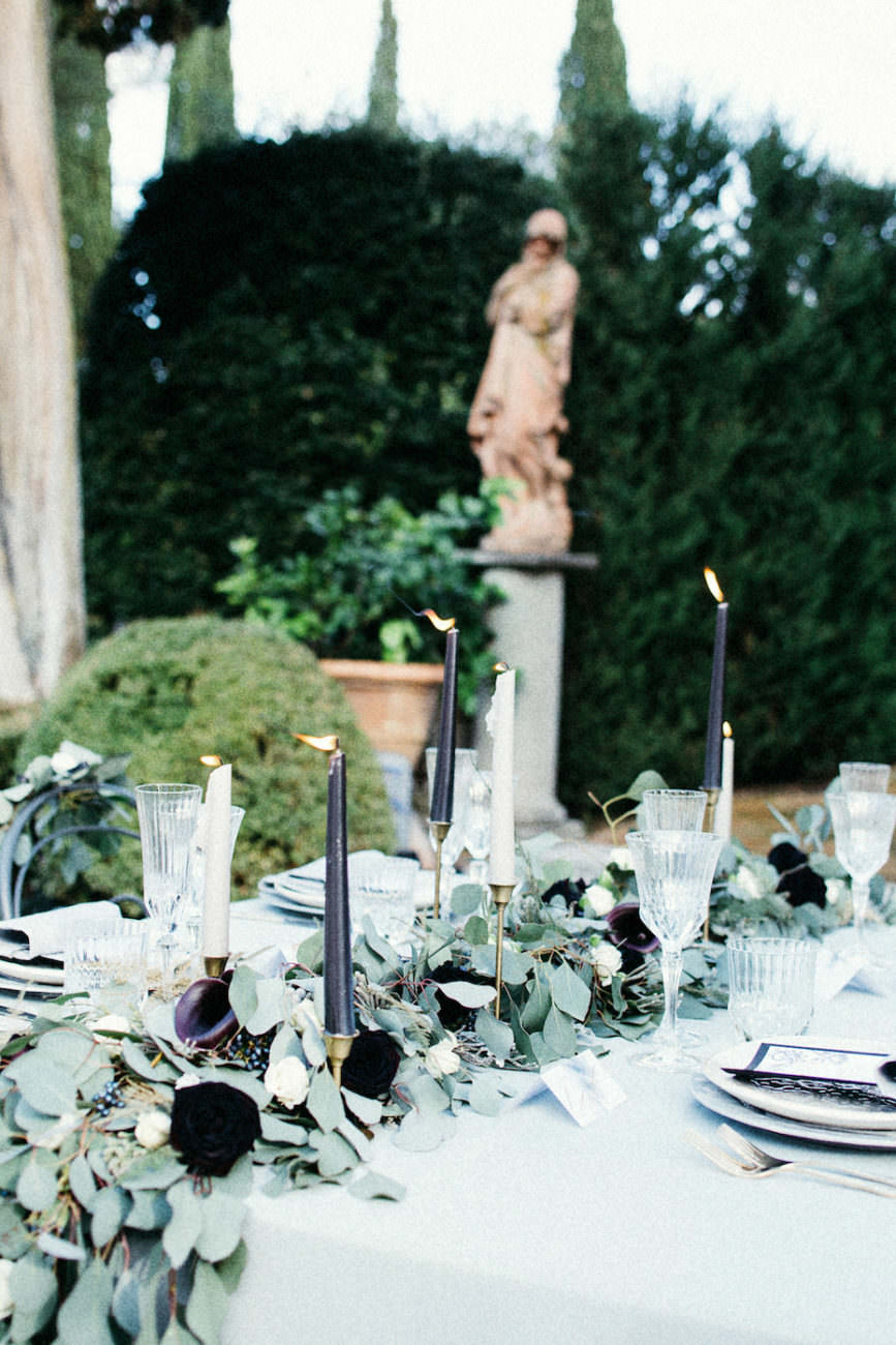 Style Shoot in Tuscany, Italy bridal reception table decoration with leaves, ferns and dark red flowers