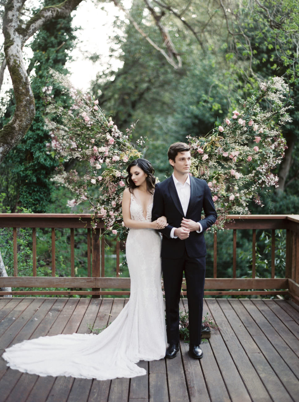 Neutral Wedding Inspiration bride and groom standing together in front of flower arrangement
