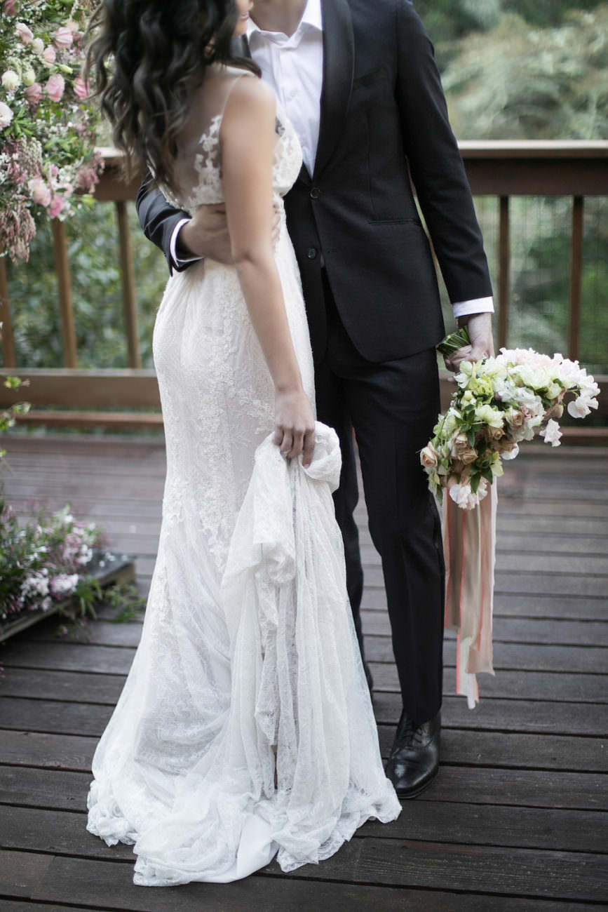 Neutral Wedding Inspiration_groom holding bride's bouquet with ribbons