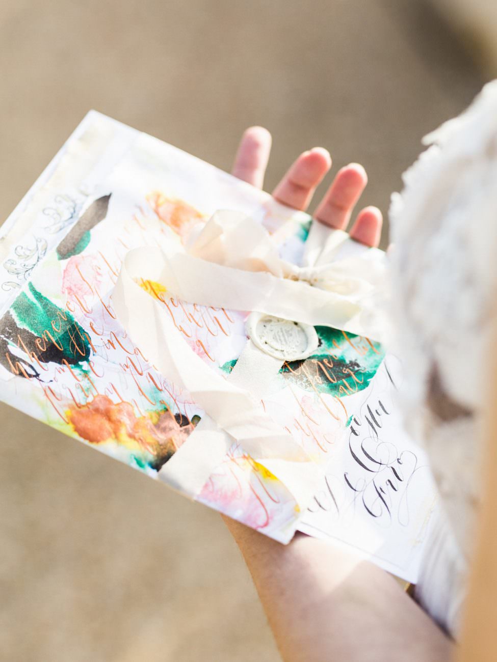 Palace Wedding Inspiration bride holding invitation and wrap