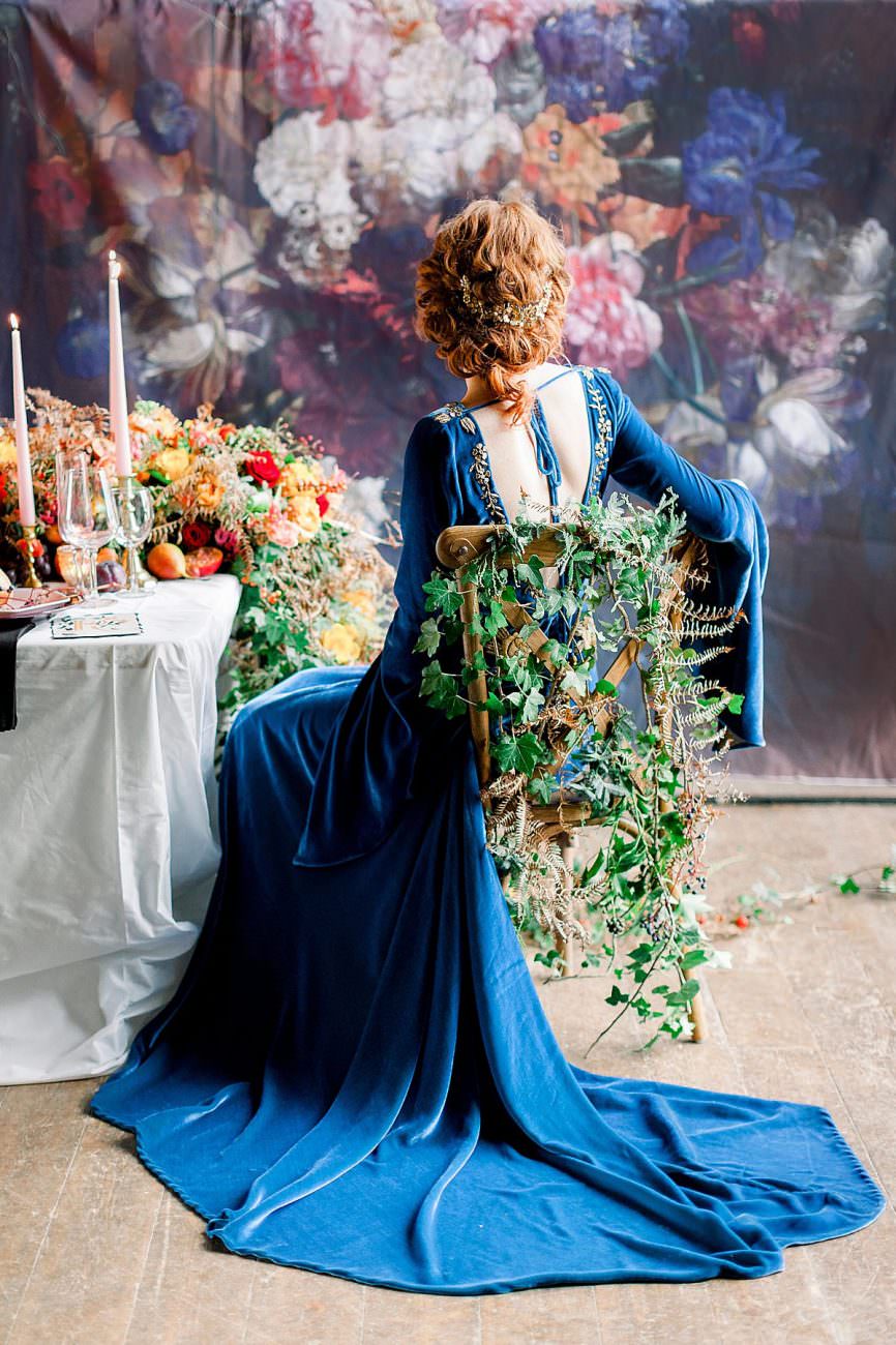 Baroque Wedding bride with blue velvet dress sitting on a chair with ivy