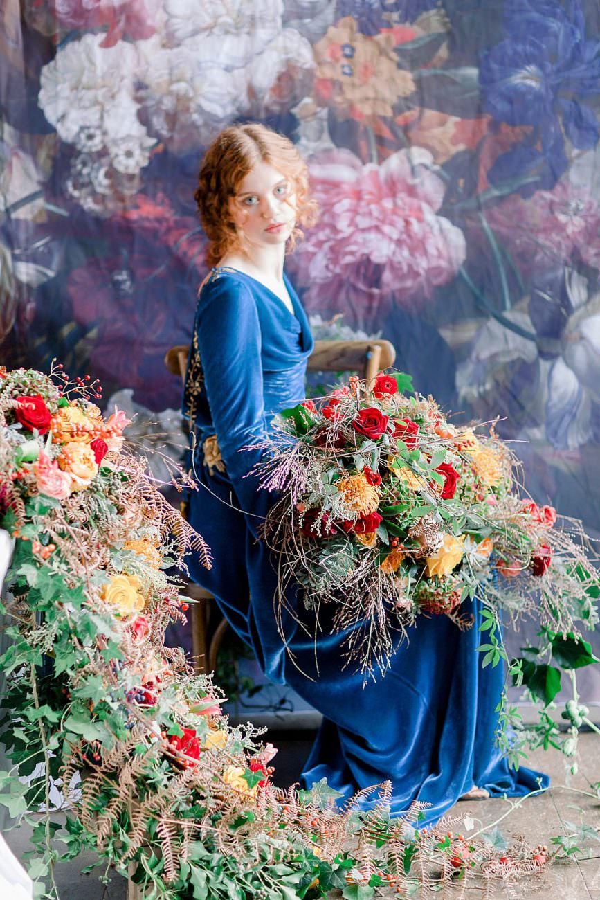 Baroque Wedding bride with blue velvet dress sitting at a table