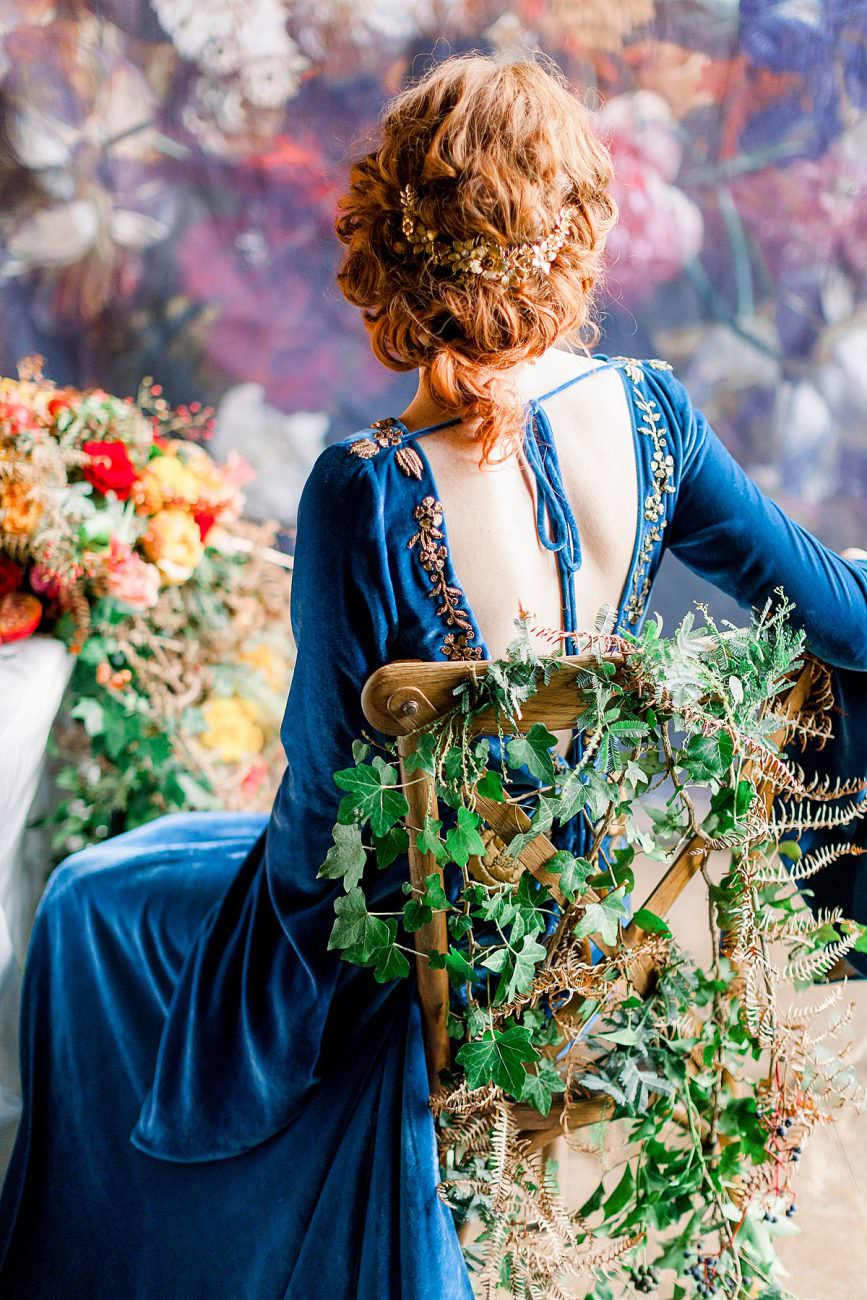 Baroque Wedding bride with bride showing the back of her blue dress with embroidery
