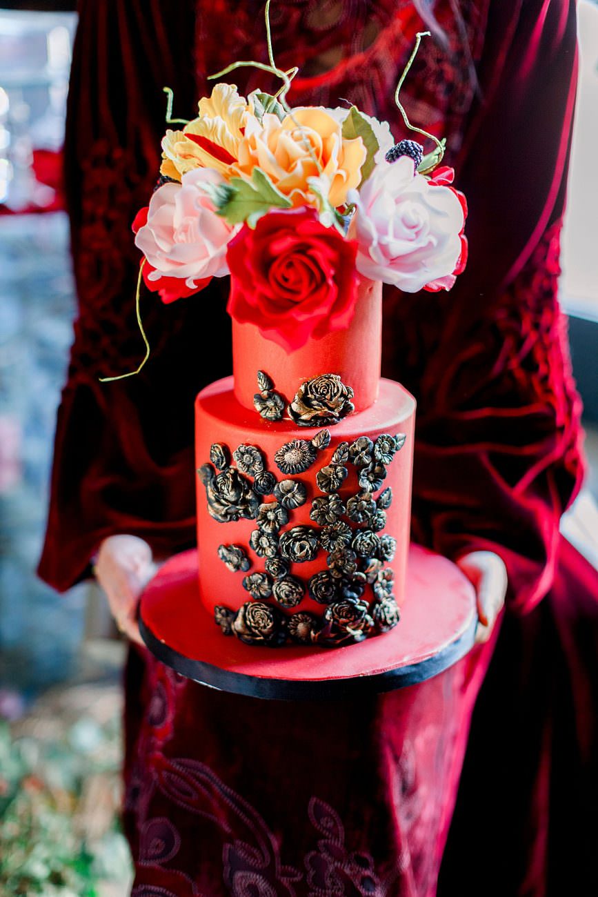 Baroque Wedding cake held by bride in a red velvet wedding dress