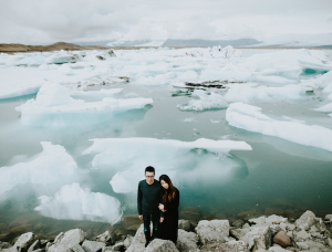 Best Destination Wedding Locations Iceland couple standing next to icebergs and mountains view