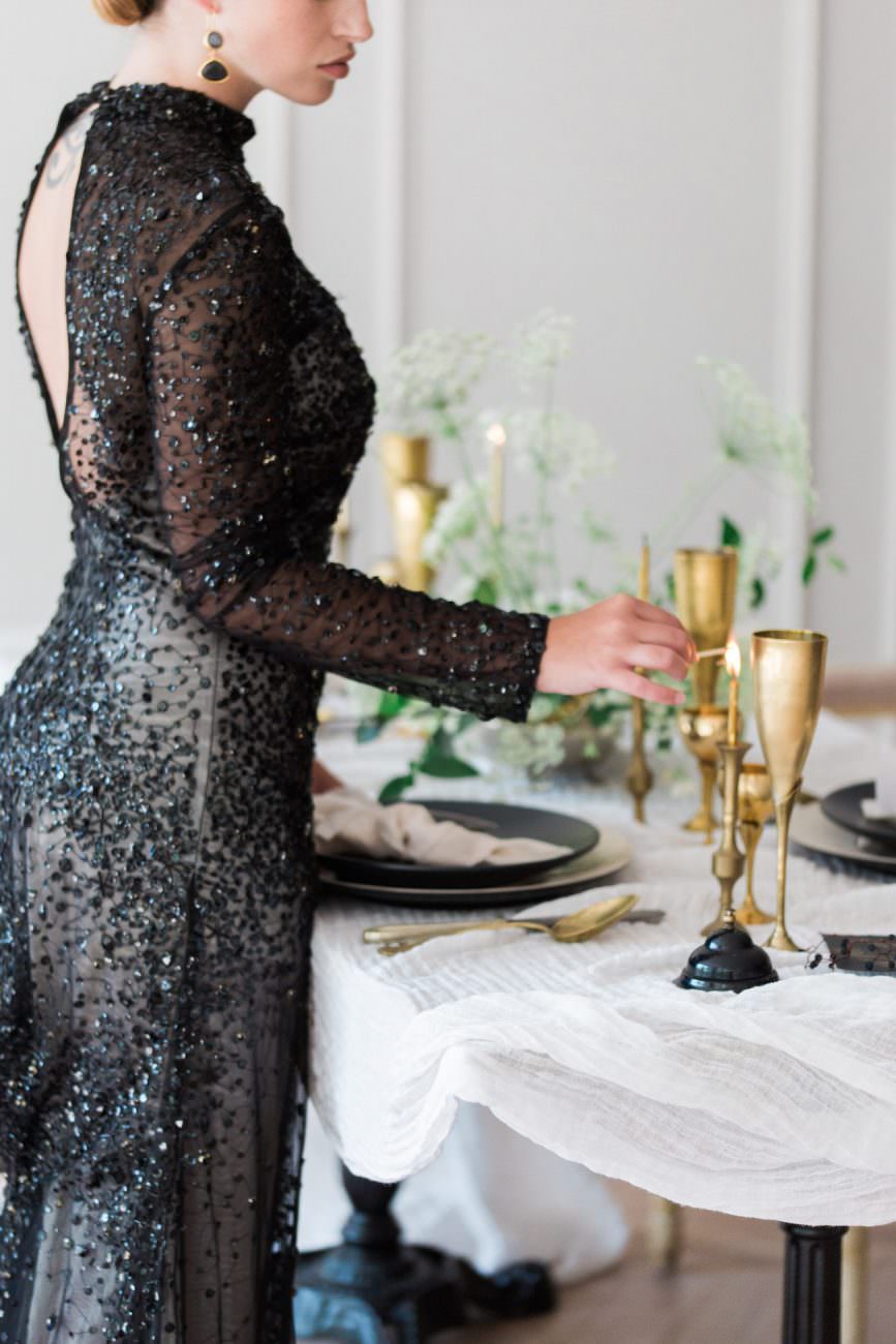 Fine Art Black Tie Wedding Inspiration Shoot bride in a long black dress lighting candles