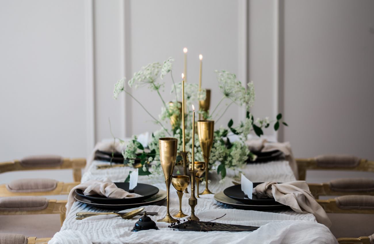 Fine Art Black Tie Wedding Inspiration Shoot with gold lit candles on a table setting