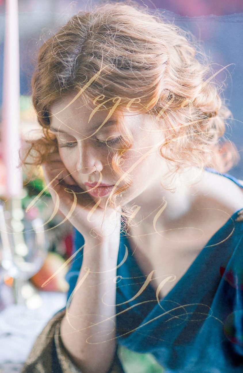 Gold calligraphy super imposed onto photo of a bride in a blue dress