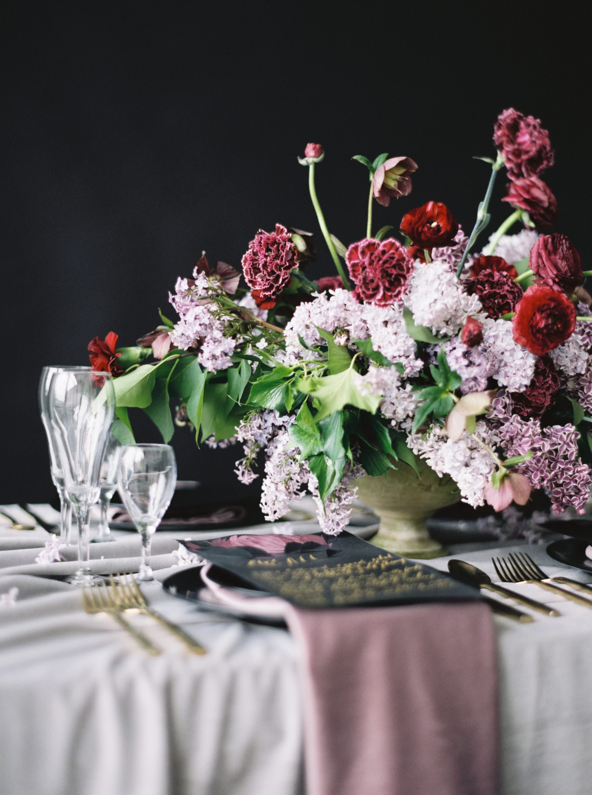 Moody table setting idea with red, lilac flowrs and a black menu design