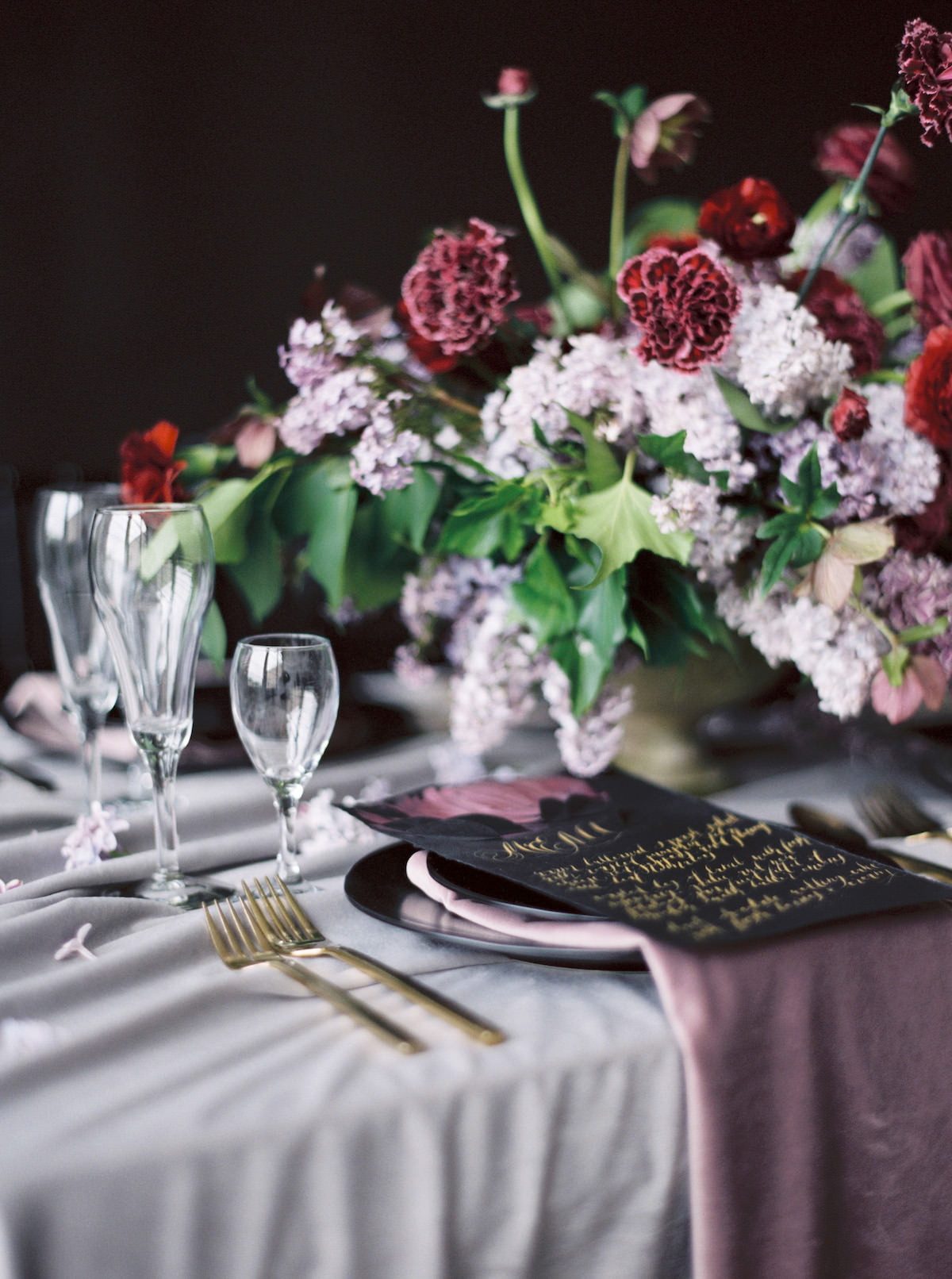 Striking moody table setting idea with black and rich red tones