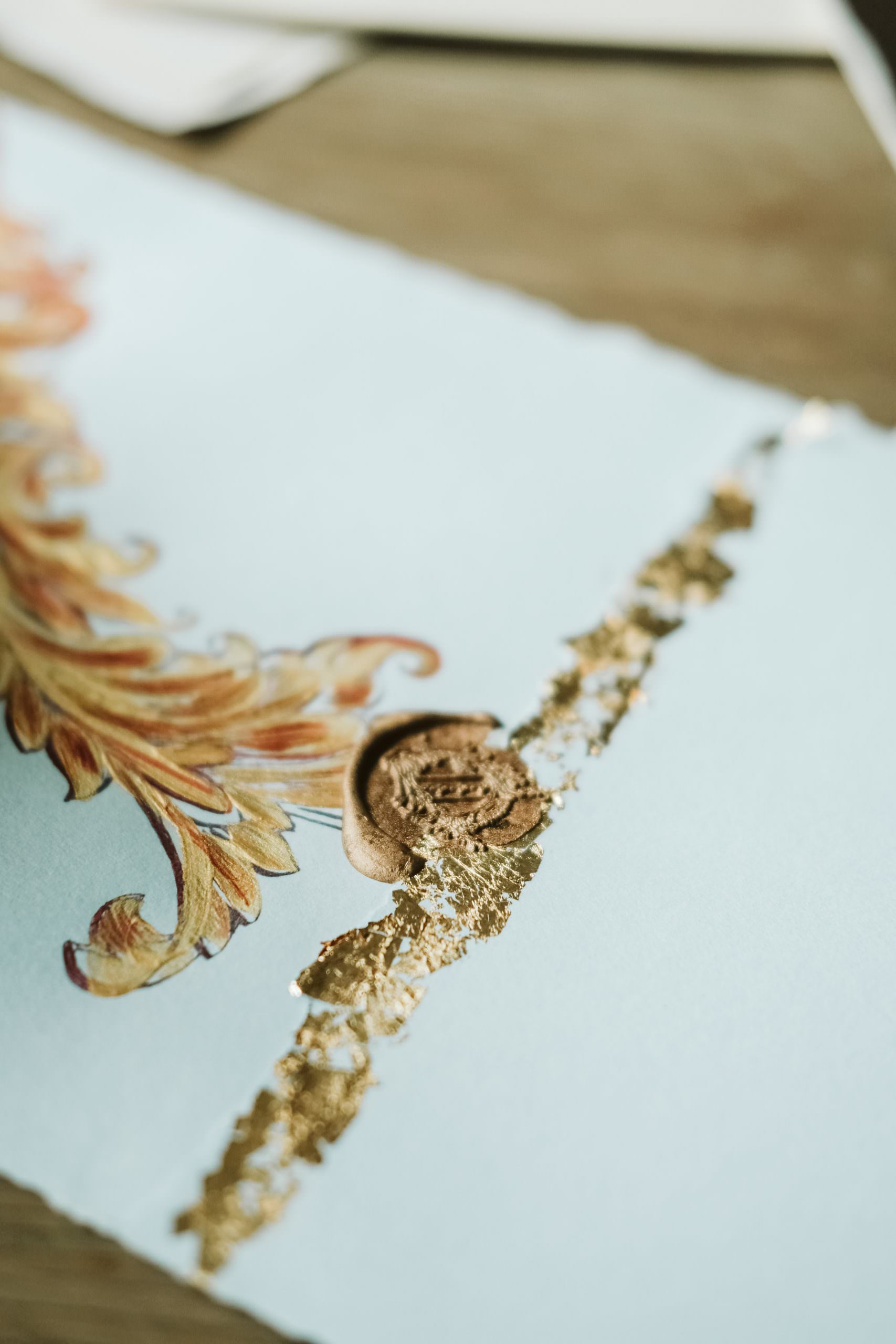 Hand Painted gold and red baroque style wedding stationery featuring a pale blue envelope