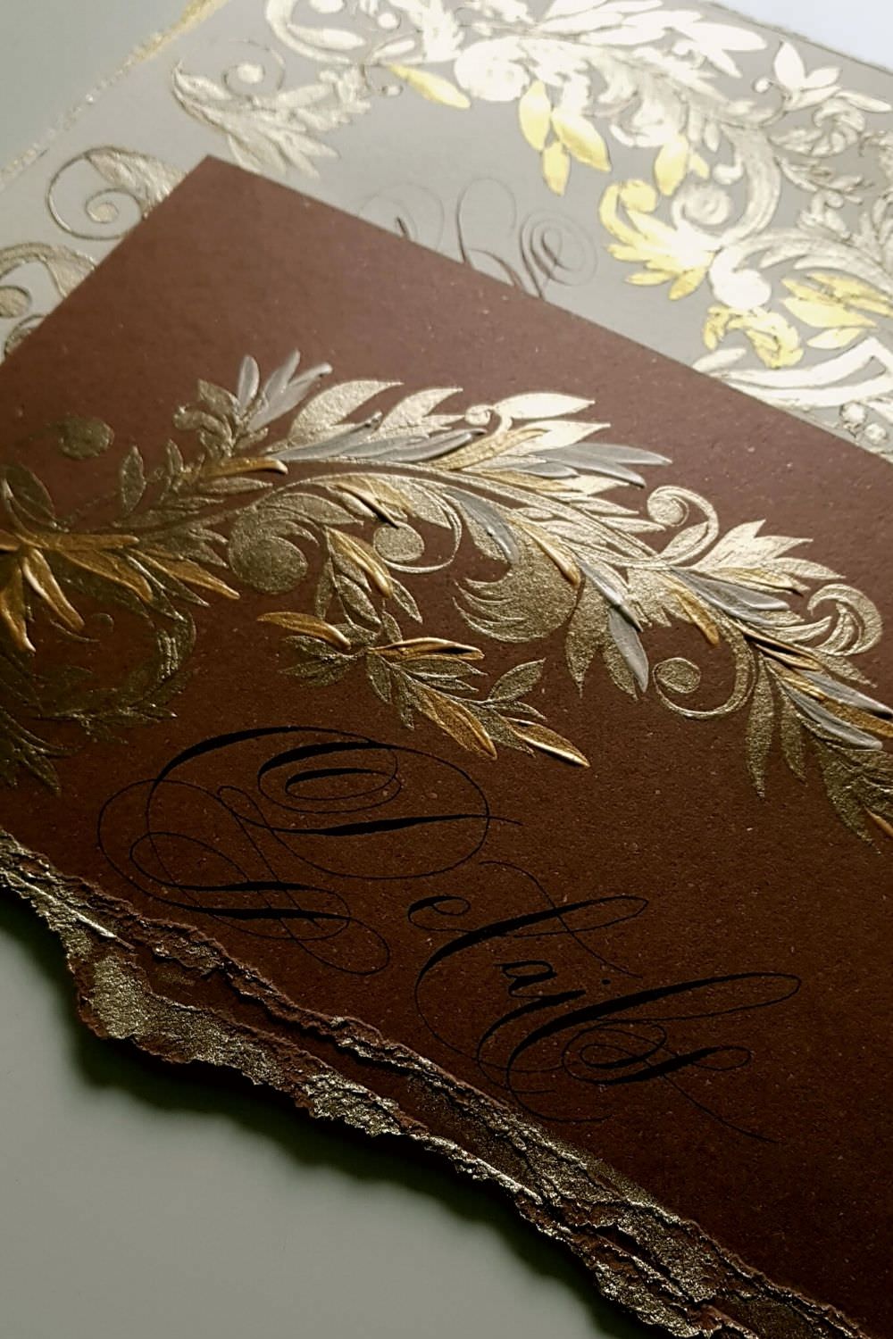 Villa Erba wedding invitations with deep brown card with gold hand painted details and a torn edge